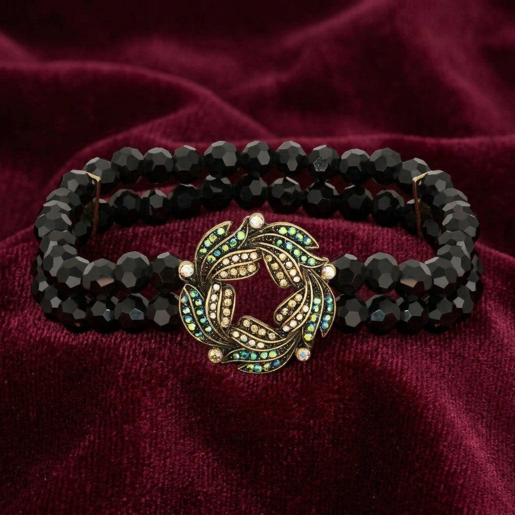 Peacock Plumage Blue Iridescent AB Black Glass Bead Wreath Bracelet resting on dark red fabric 