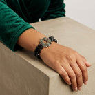 Woman wearing our Peacock Plumage Blue Iridescent AB Black Glass Bead Wreath Bracelet on her wrist