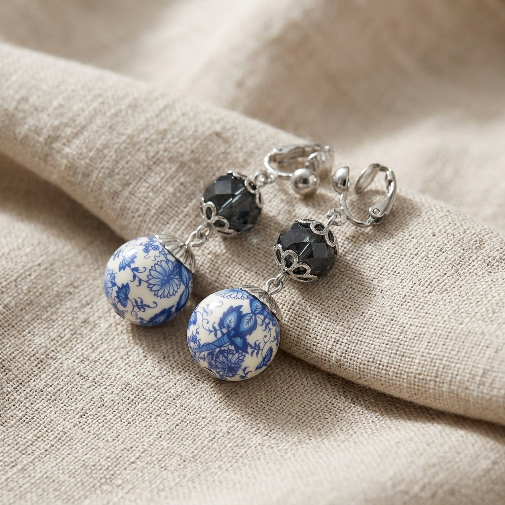 Blue Willow drop bead clip on earrings resting on beige fabric