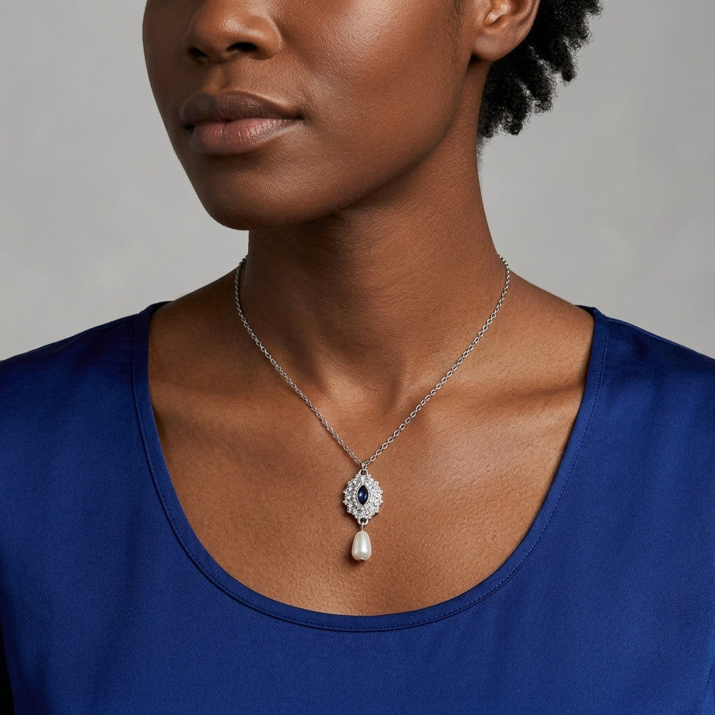 Woman in a blue top wearing our blue crystal Starburst Crystal Faux Pearl Drop Pendant Necklace