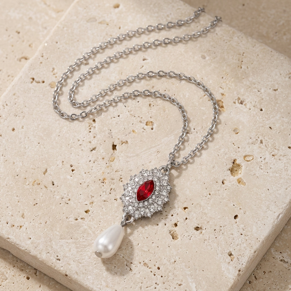 Starburst Crystal Faux Pearl Drop Pendant Necklace on a textured beige stone surface