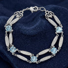 Silver tone bracelet with light sapphire blue Austrian crystals resting on a sparkling dark blue stone surface