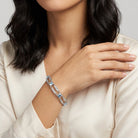 Woman wearing a silver tone bracelet with light sapphire blue Austrian crystals on her wrist