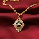 Gold necklace with a detailed pendant featuring a Pegasus on a red fabric background