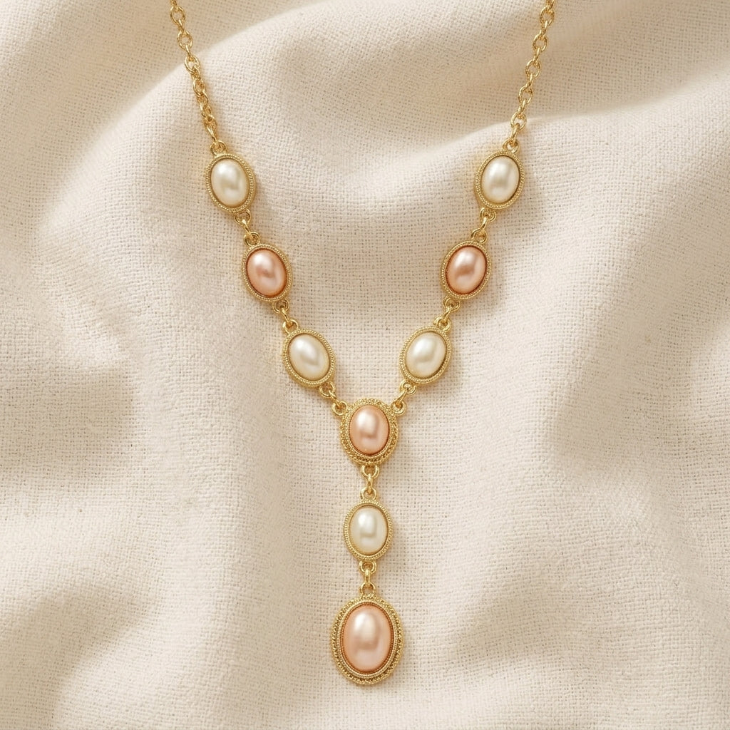 Rosabella pink and white faux pearl necklace resting on white linen surface