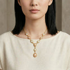 Woman in a white top wearing a Rosabella pink and white faux pearl necklace
