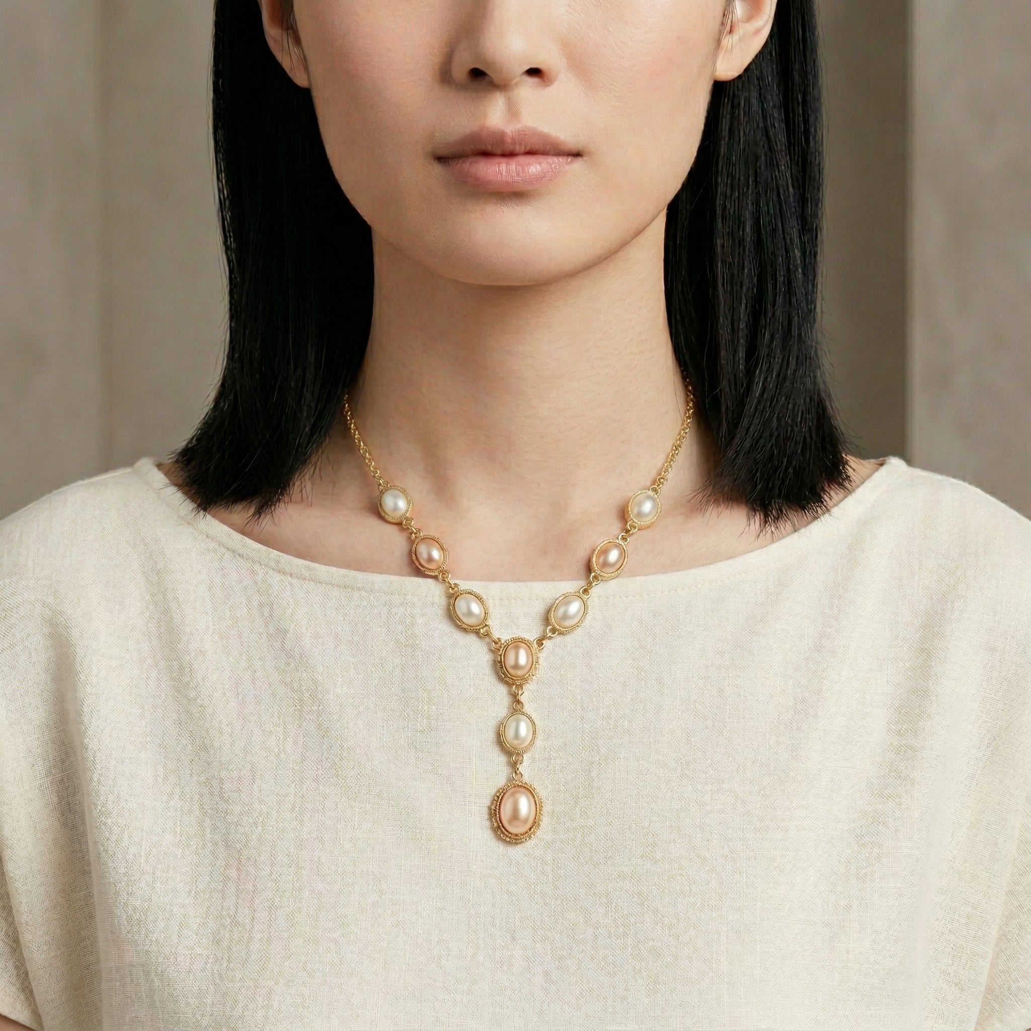 Woman in a white top wearing a Rosabella pink and white faux pearl necklace