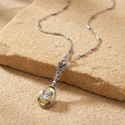 Silver tone long horse head design photo locket pendant necklace resting on sandstone surface