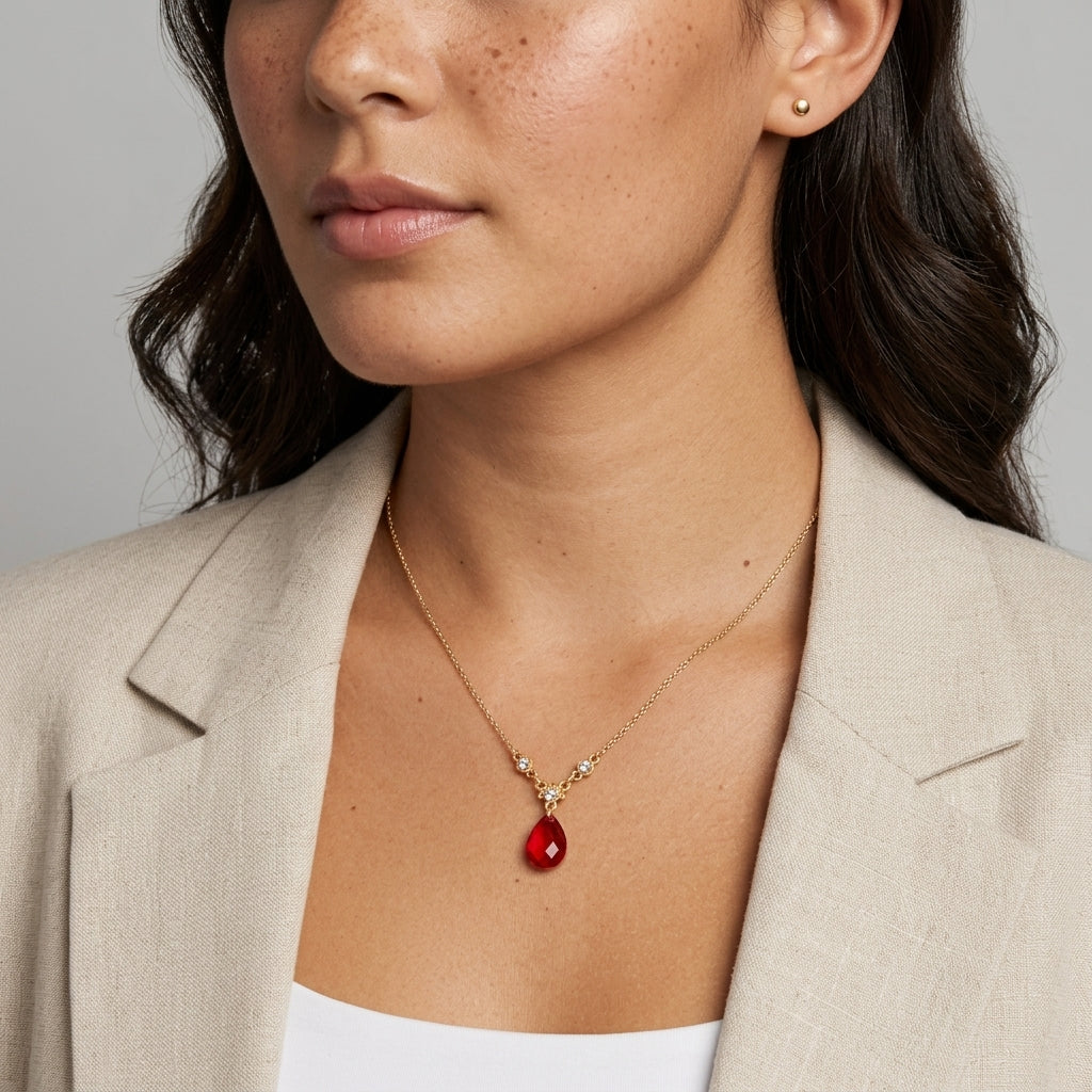 Woman wearing a red teardrop pendant necklace with clear crystal accents