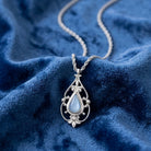 Blue stone pendant necklace on a blue fabric surface