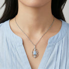 Blue stone pendant necklace worn by a woman with a v-neck blouse