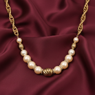 Pearl and gold necklace on a burgundy fabric background