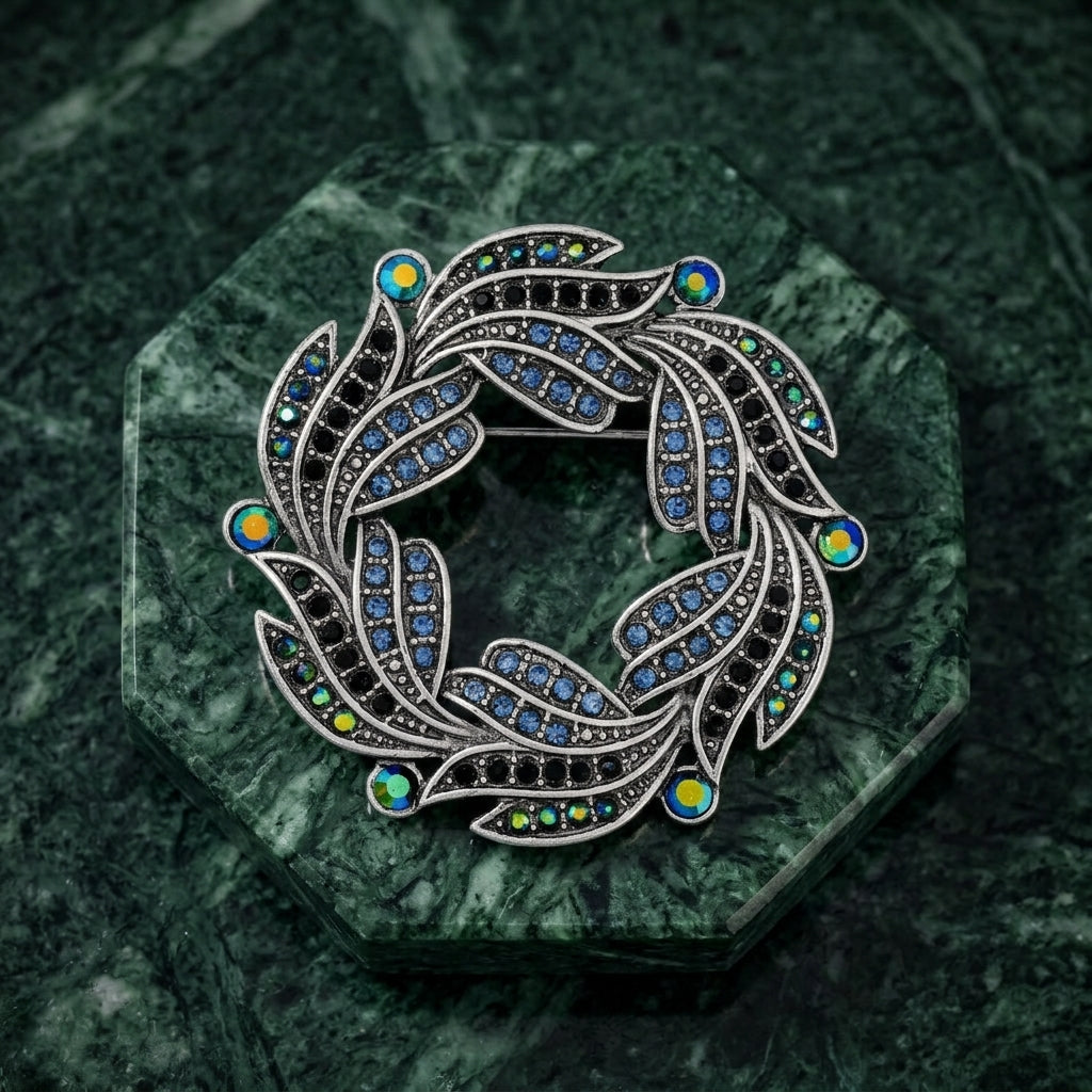 Decorative wreath brooch with AB crystals on a green marble background