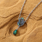 Montana blue and AB crystal drop pendant necklace resting on brown sandstone surface