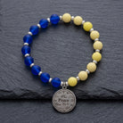 Ukraine color peace charm bracelet resting on a dark stone surface