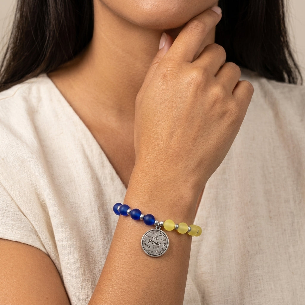 Ukraine colors peace charm bracelet worn by a model on her wrist