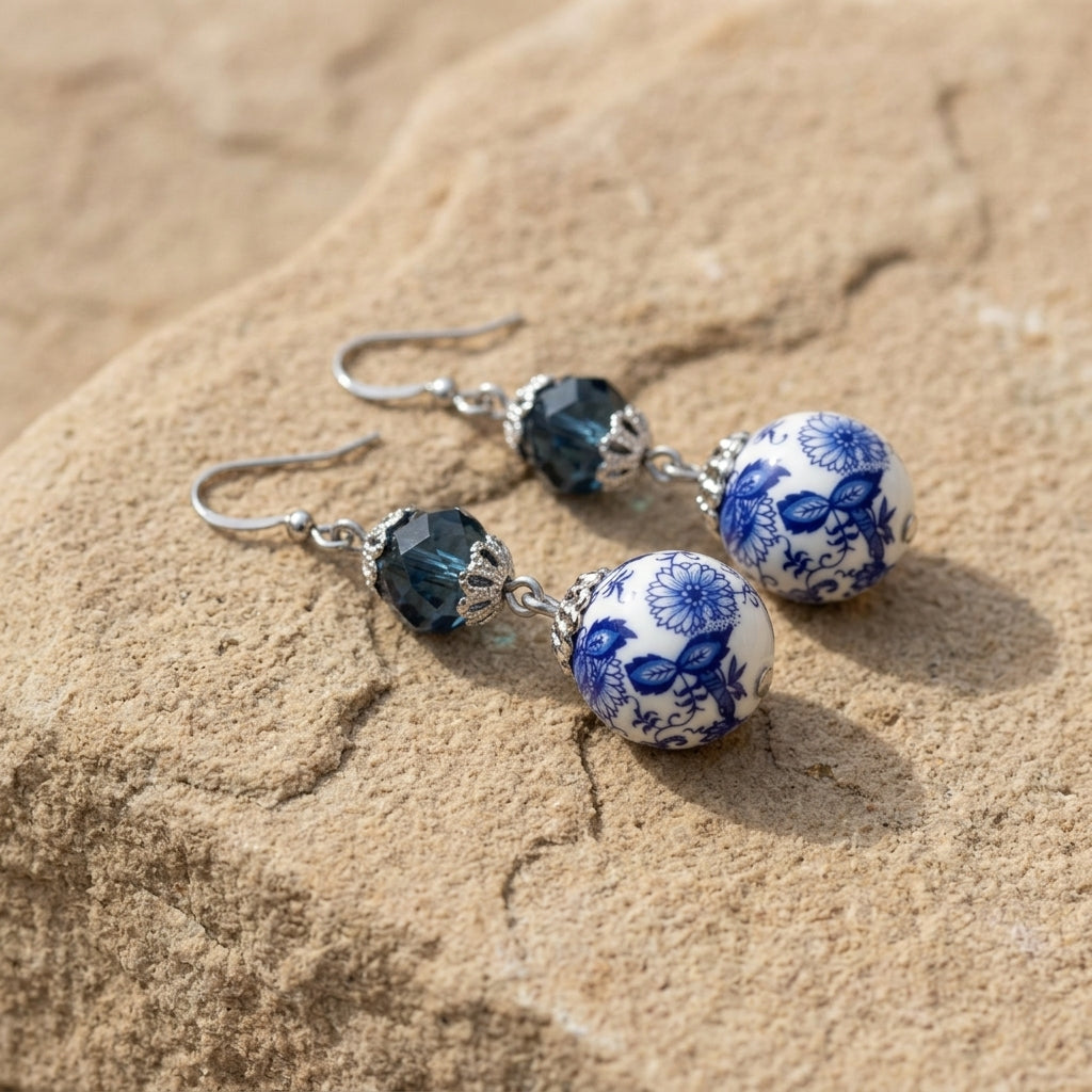 Blue Willow Dark Blue And Beaded Dangle Earrings resting on beige stone surface
