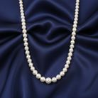 Faux pearl necklace on a blue satin background