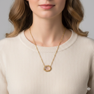 Necklace with a clear amethyst pendant and inner floral design worn by a person against a neutral background