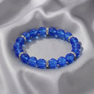 Blue beaded bracelet with silver accents on a gray fabric background