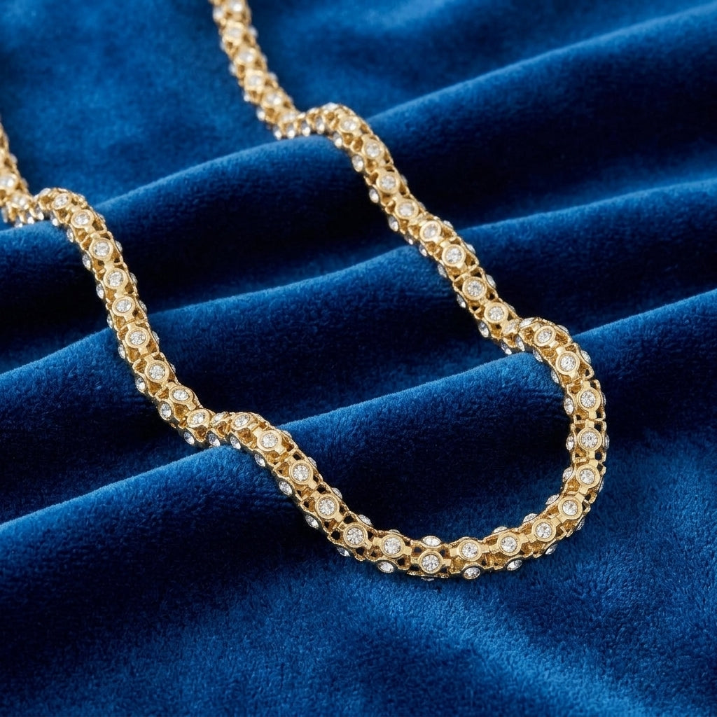 Gold necklace with pave crystals on a blue velvet background