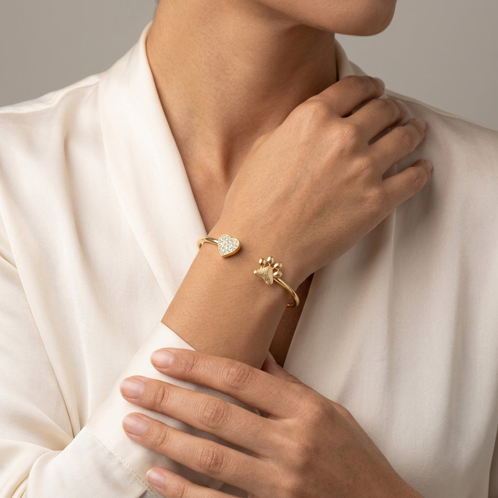 Woman wearing a gold tone heart and pet paw crystal spring bracelet on her wrist