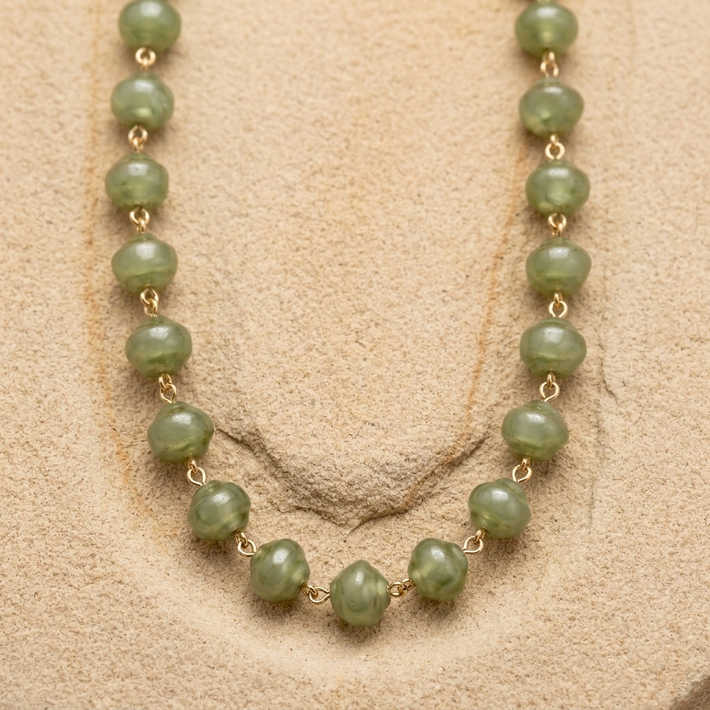 Necklace with green beads on a beige background