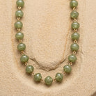 Necklace with green beads on a beige background