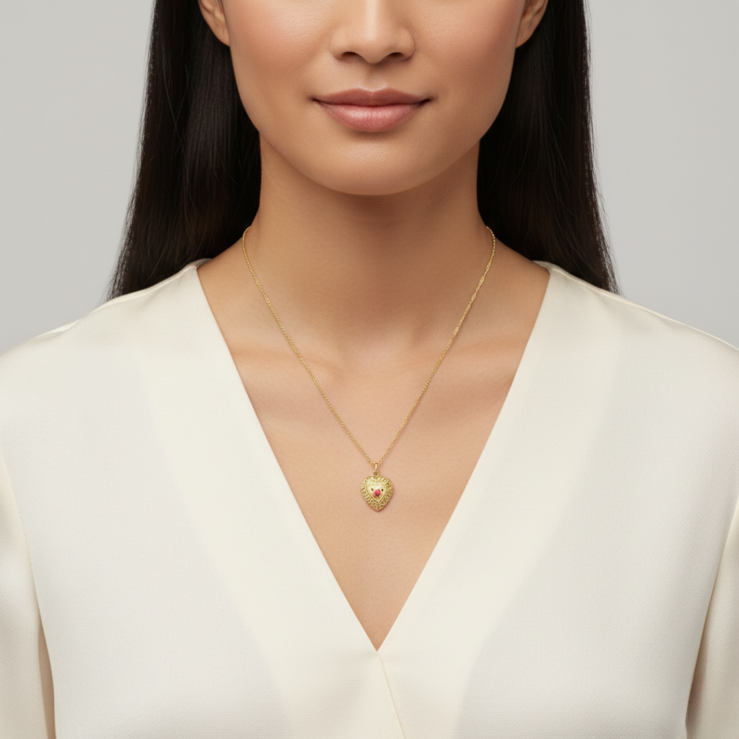 Woman wearing a gold necklace with a heart pendant against a neutral background