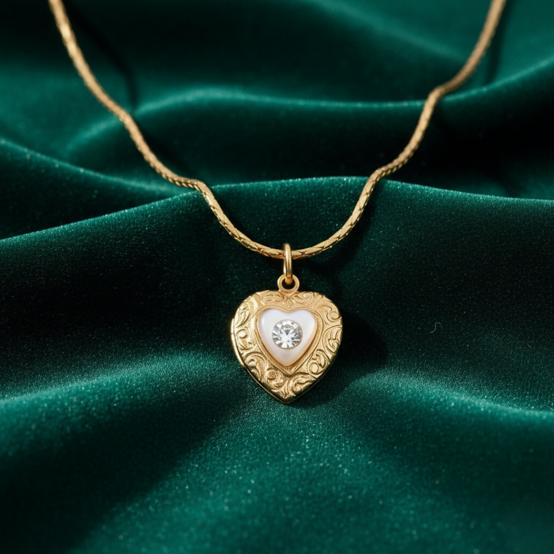 Gold heart-shaped necklace with a crystal on a green velvet background
