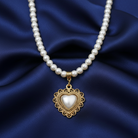Faux pearl necklace with a heart-shaped pendant on blue fabric