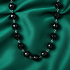 Black beaded necklace on a green satin background