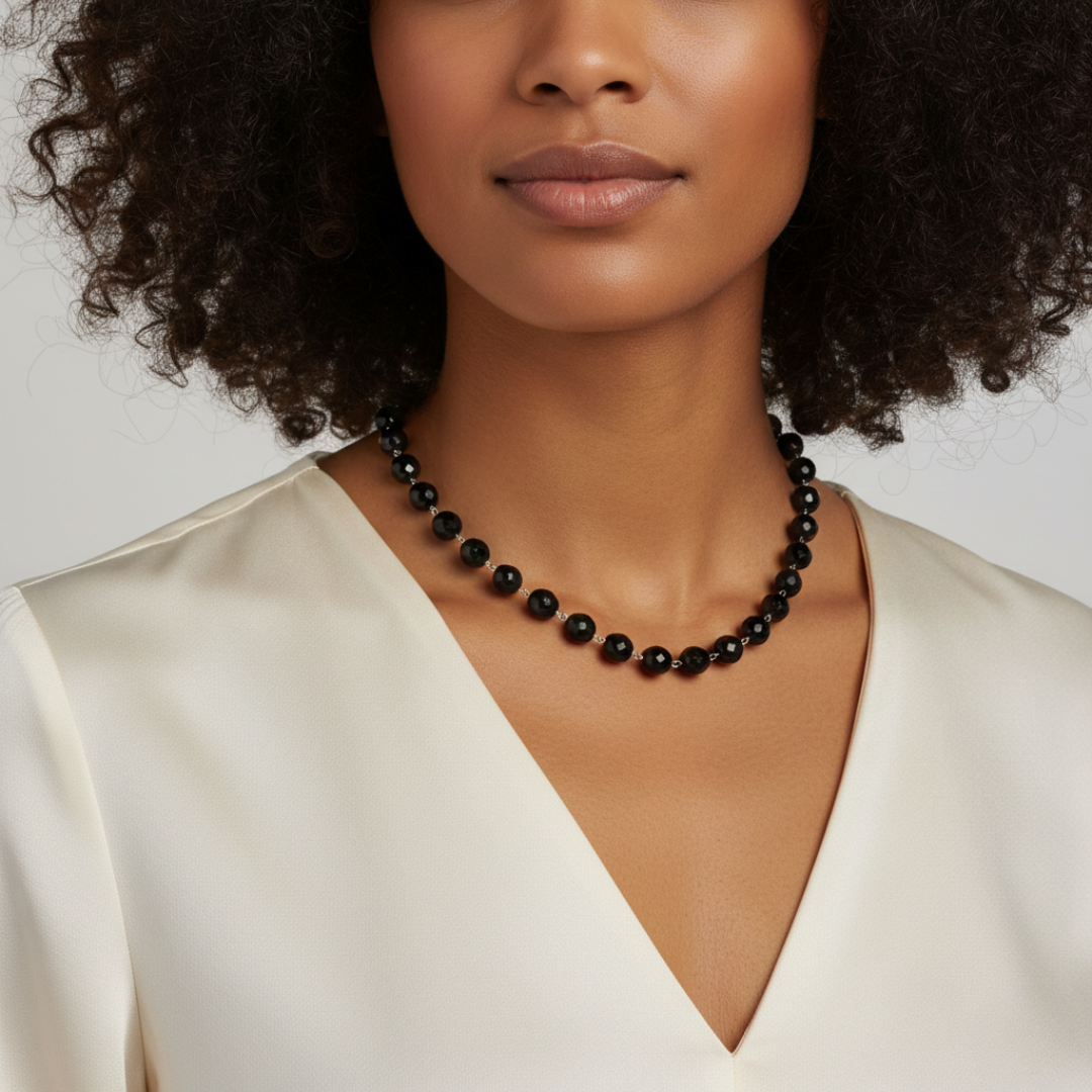 Woman wearing a black beaded necklace against a neutral background