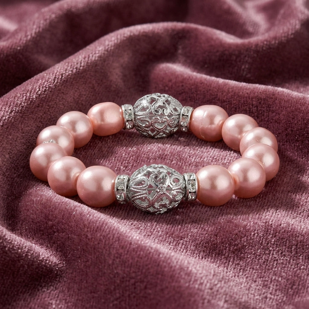 Pink pearl bracelet with silver decorative beads on a purple fabric background
