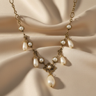 Pearl necklace with gold chain on a beige fabric background