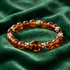 Bracelet with brown beads on a green fabric background