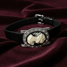 Black leather bracelet with featuring a classical design on a purple fabric background. 