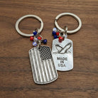 Two keychains with American flag and eagle design on a wooden surface
