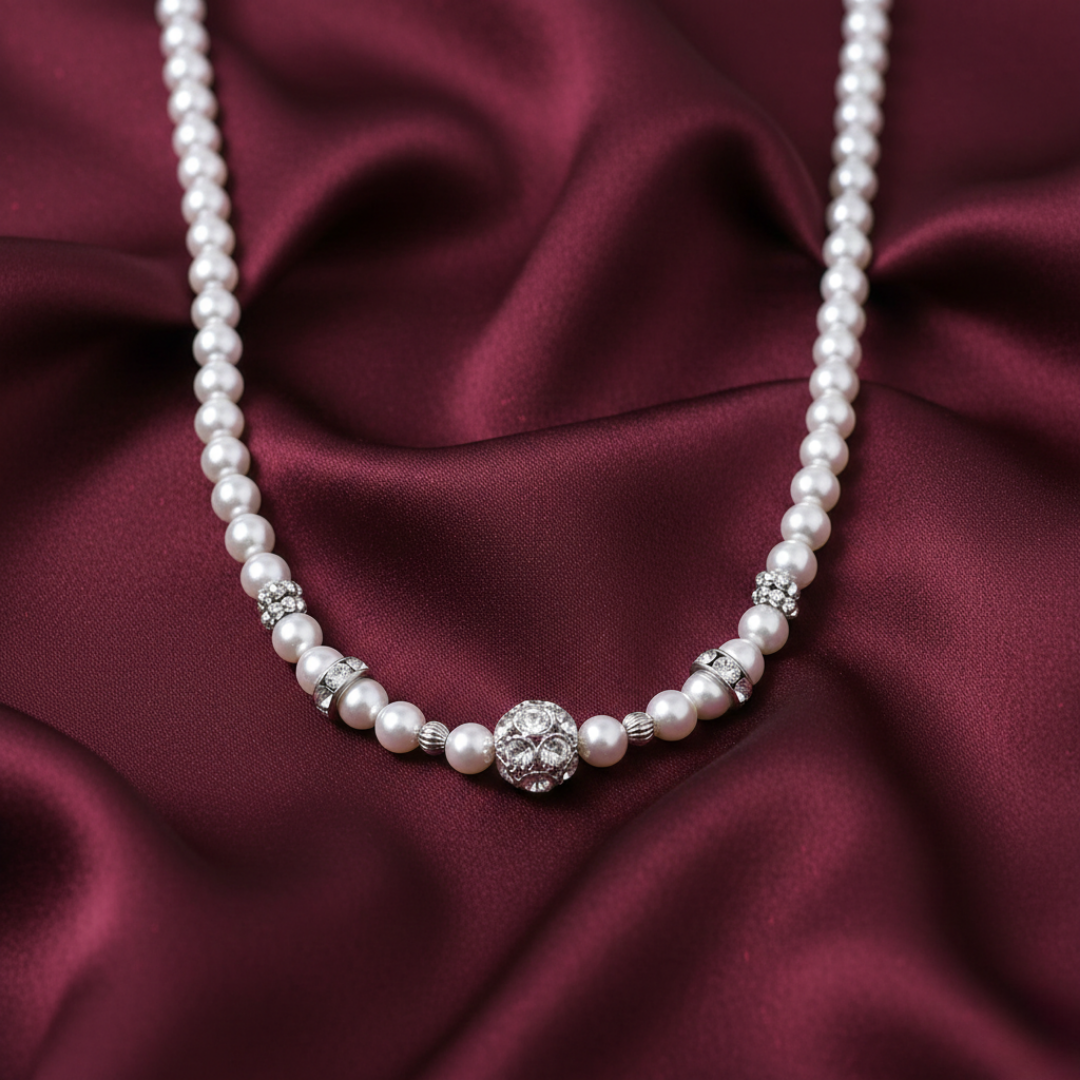 Faux pearl necklace with a silver clasp on a burgundy satin background