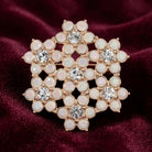 Decorative brooch with gemstones and crystals on a maroon fabric background