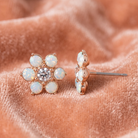 Opal Radiance Stone & Crystal Flower Stud Earrings displayed on a peach velvet surface.