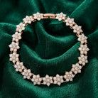 Rose gold bracelet with floral opal radiance design on a green fabric background