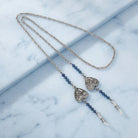 Necklace eyeglass holder with heart-shaped pendants on a marble surface