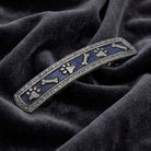 Decorative hair barrette with pet paw and bone designs on a dark fabric background