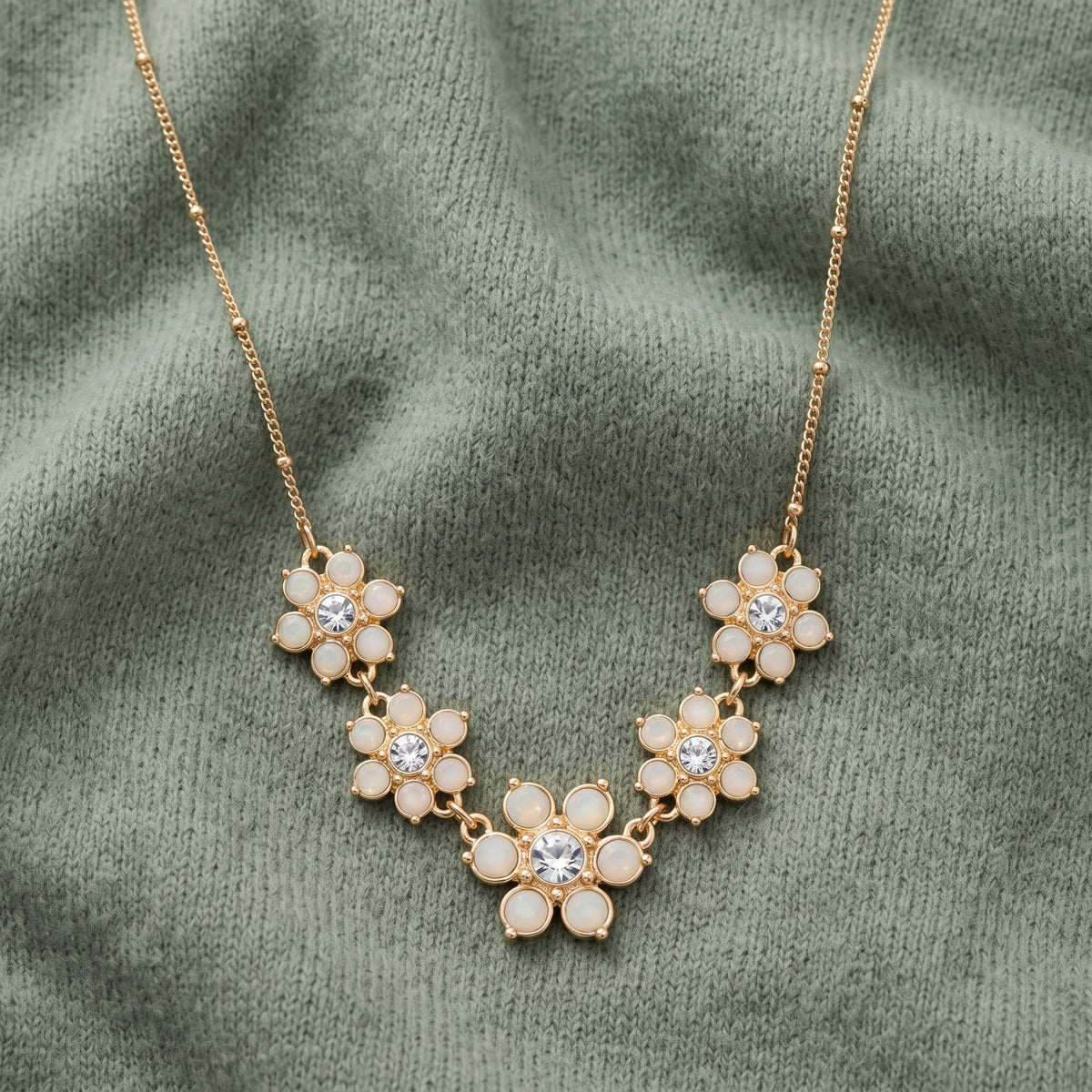 Opal Radiance Stone & Crystal Flower Drop Necklace 16" + 3" Extension displayed on sage green fabric