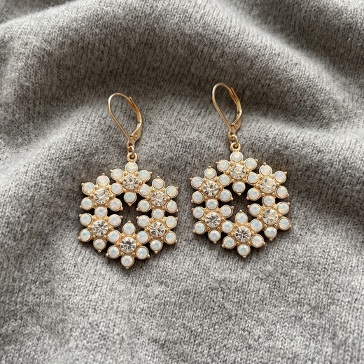 Opal Radiance Stone & Crystal Snowflake Drop Earrings displayed on a textured gray fabric background.