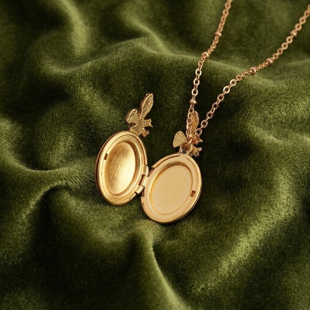 Gold floral locket necklace on a green fabric background