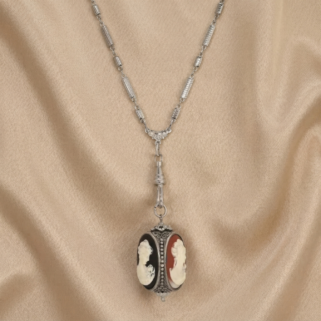 Necklace with a 3-sided cameo pendant on a beige fabric background
