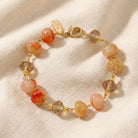 Bracelet with carnelian marbled and clear beads on a beige fabric background