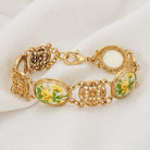 Gold bracelet with floral accents on a white fabric background